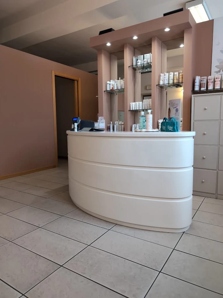 Reception di Jolie, con bancone bianco laccato e pareti rosa cipria